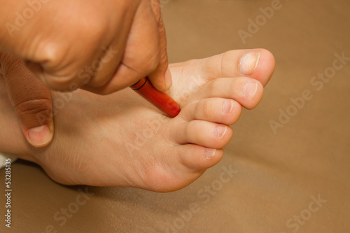 Reflexology foot massage  thai spa foot treatment by wood stick