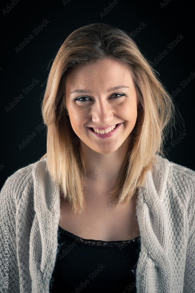 Smiling blonde woman close up portrait on dark background. Smiling blonde woman close up portrait on dark background.