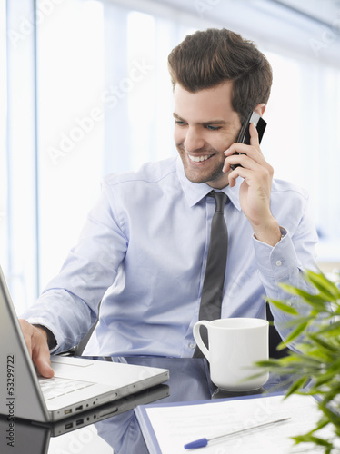 Smiling businessman talking on a mobile phone.