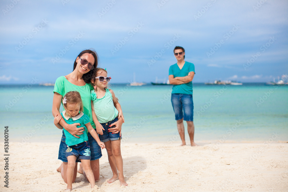 Mom with her cute daughters in the foreground and dad in the Mom with her cute daughters in the foreground and dad in the