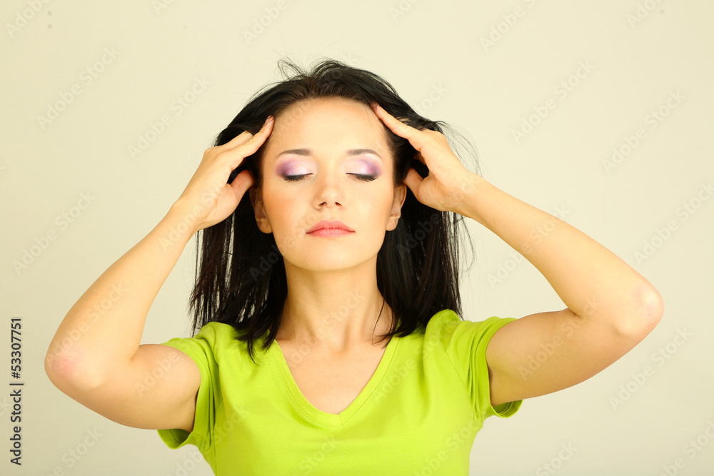 Young woman have headache on grey background Young woman have headache on grey background