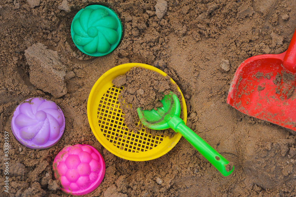 multicoloured toy lying on a wet sand multicoloured toy lying on a wet sand