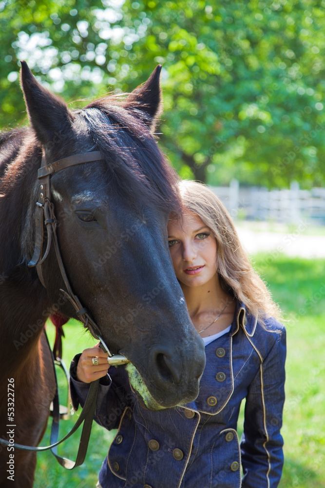 Fototapeta premium Young girl walking with a horse in the garden.