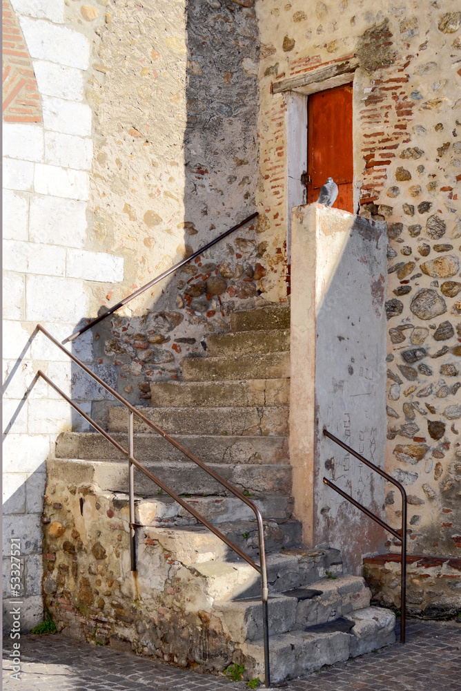 Obraz premium vieil escalier conduisant à une petite porte rouge