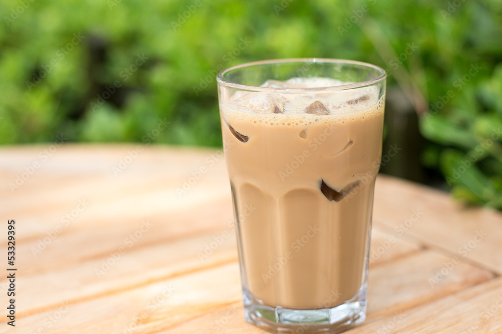 Cold ice coffee with cubes on wooden table Cold ice coffee with cubes on wooden table