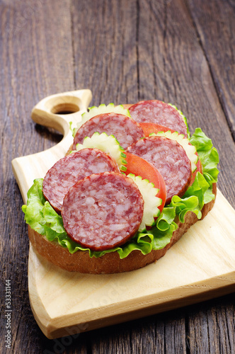 Sandwich with sausage, tomato and cucumber
