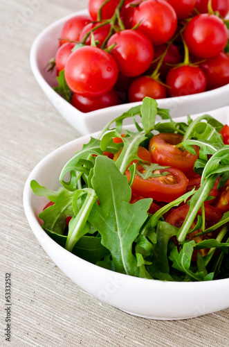 bowl of fresh green  natural arugula and cherry tomatoes