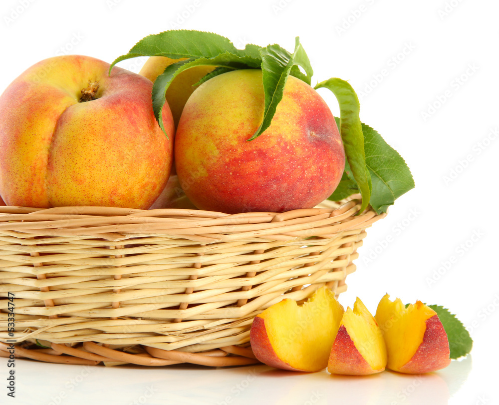 Ripe sweet peaches with leaves in basket, isolated on white Ripe sweet peaches with leaves in basket, isolated on white