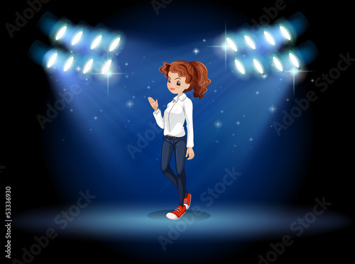 A lady standing at the stage under the spotlights