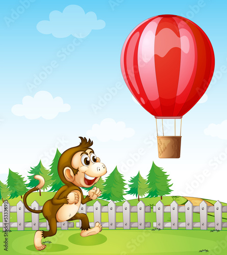 A monkey running outside the fence with a hot air balloon