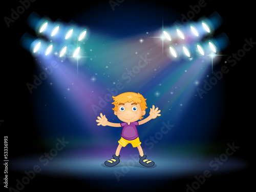 A cute little boy dancing in the middle of the stage