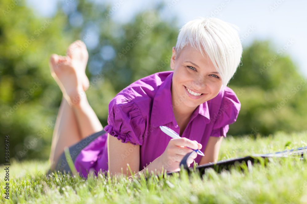Beautiful female student is studying in a green field Beautiful female student is studying in a green field