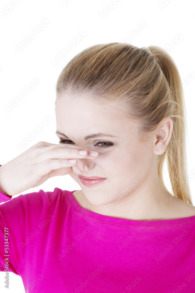 Woman covers nose with hand showing that something stinks Woman covers nose with hand showing that something stinks