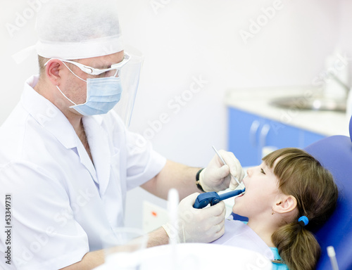 dentist using dental filling gun on kid