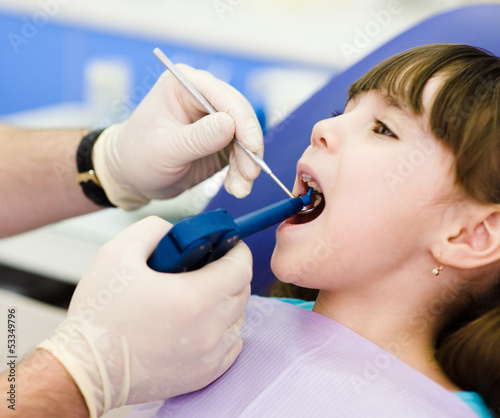 dentist using dental filling gun on kid