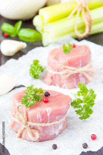 Fresh fillet of raw meat with spices and herbs on a wooden backg