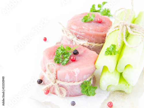 Two isolated fresh fillet of raw meat with celery, spices and he
