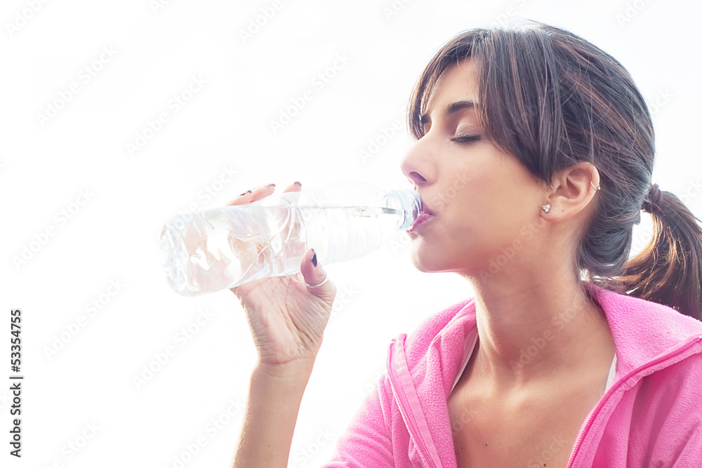 Young caucasian woman drinking water from a bottle Young caucasian woman drinking water from a bottle