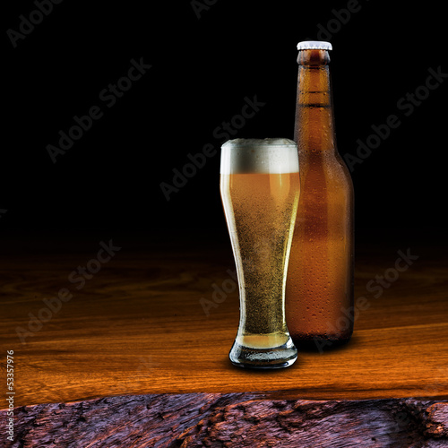 Glass and bottle of beer on wood table