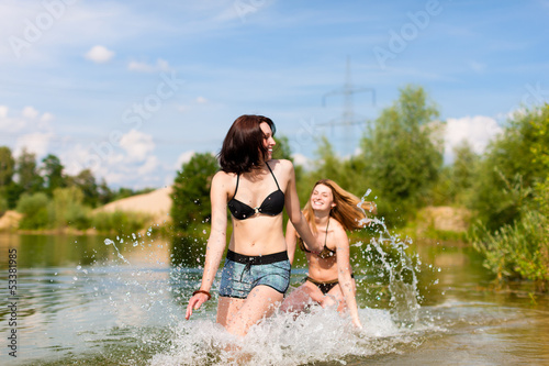 Zwei glückliche Frauen haben Spaß am See