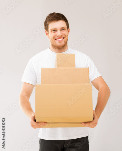 smiling man carrying carton boxes