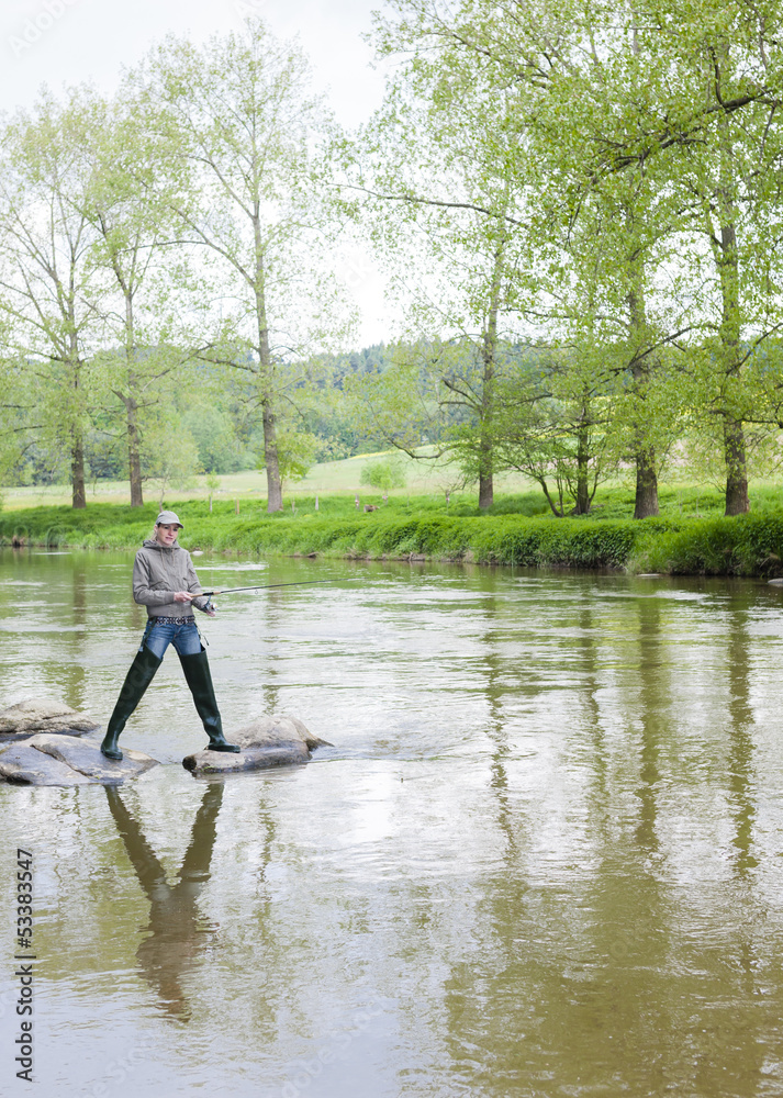 woman fishing in Sazava river, Czech Republic woman fishing in Sazava river, Czech Republic