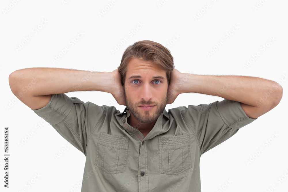 Man blocking his ears and looking at camera Man blocking his ears and looking at camera