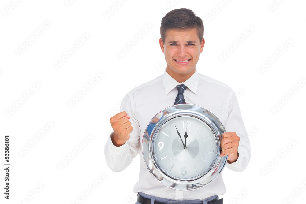Fearful businessman holding and looking at clock Fearful businessman holding and looking at clock
