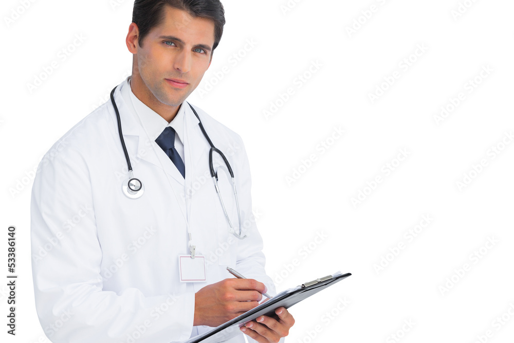 Doctor writing on his clipboard and looking at camera Doctor writing on his clipboard and looking at camera