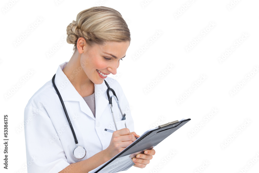 Smiling nurse writing on clipboard Smiling nurse writing on clipboard