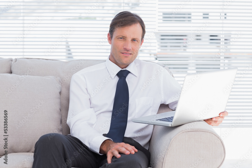 Businessman sitting on couch looking at camera Businessman sitting on couch looking at camera