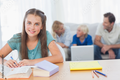 Smiling little girl doing her homework