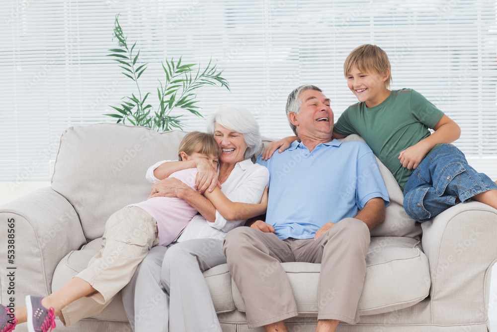 Smiling grandchildren embracing their grandparents Smiling grandchildren embracing their grandparents