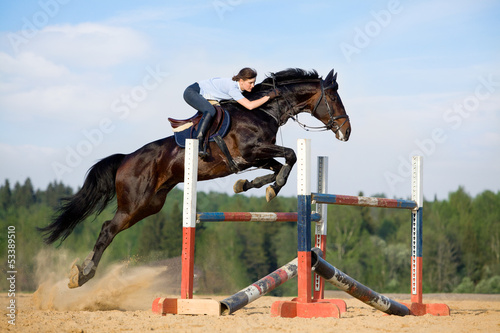 Fototapeta Horse jumping - Młoda dziewczyna na koniu.