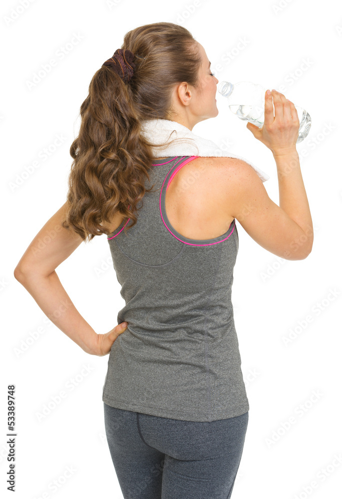 Fitness young woman drinking water . rear view Fitness young woman drinking water . rear view