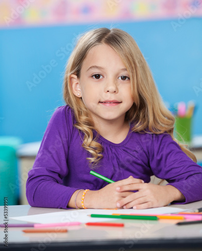 Girl With Colored Sketch Pens And Paper At Desk