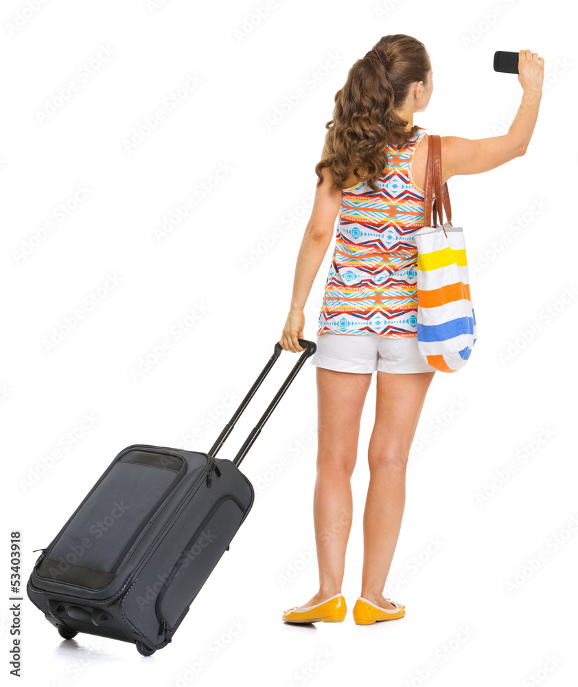 Young tourist woman with wheel bag taking photo . rear view Young tourist woman with wheel bag taking photo . rear view