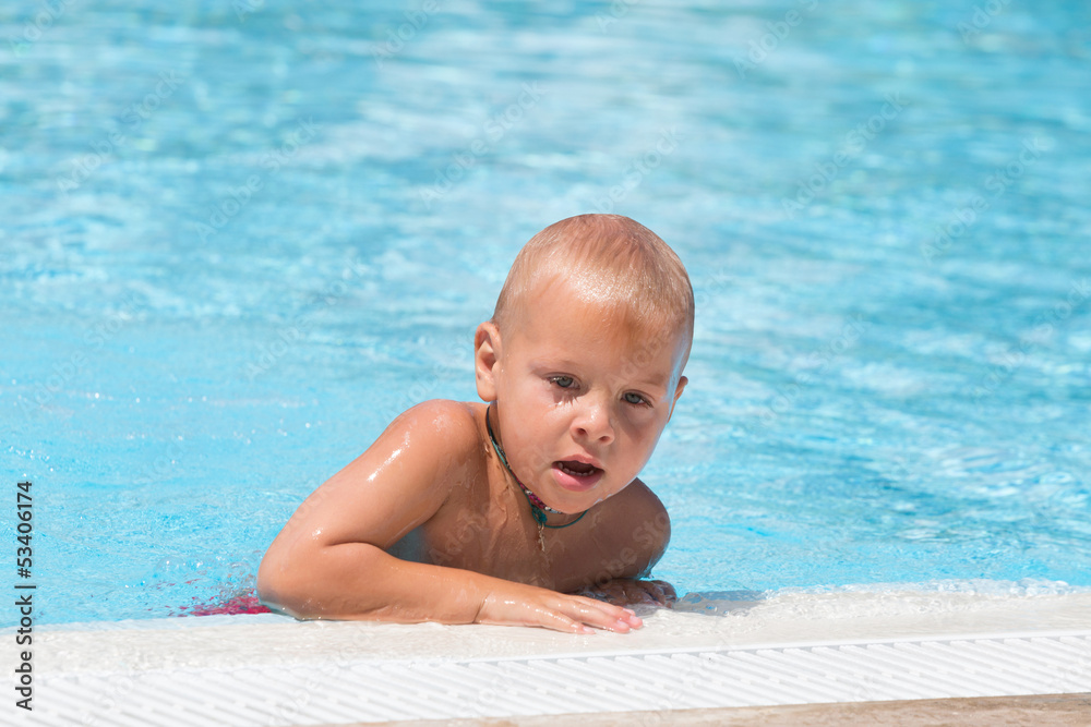 Boy with chaplet around his neck in swimming pool Boy with chaplet around his neck in swimming pool