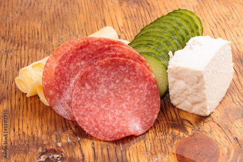 Feta and ementhal cheese with salami and cucumber photo