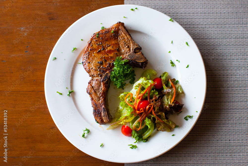 Pork chop with salad on table top view Pork chop with salad on table top view
