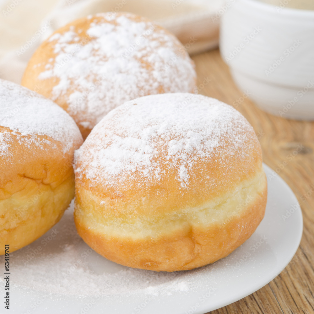 three donuts sprinkled with powdered sugar