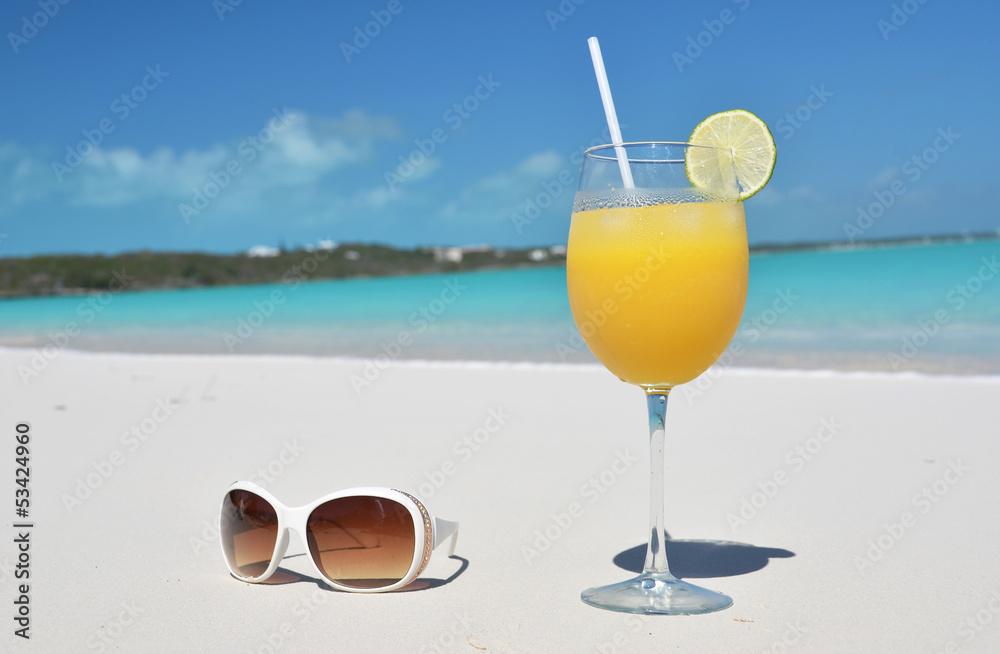 Orange juice and sunglasses on the beach. Exuma, Bahamas Orange juice and sunglasses on the beach. Exuma, Bahamas