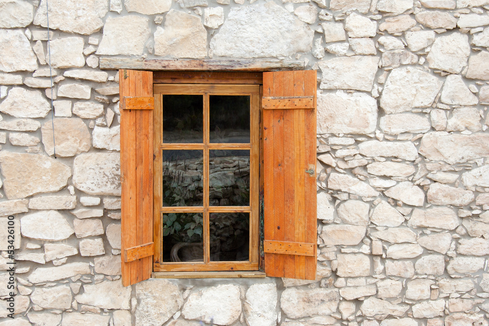 Wooden window and shutters in stone wall