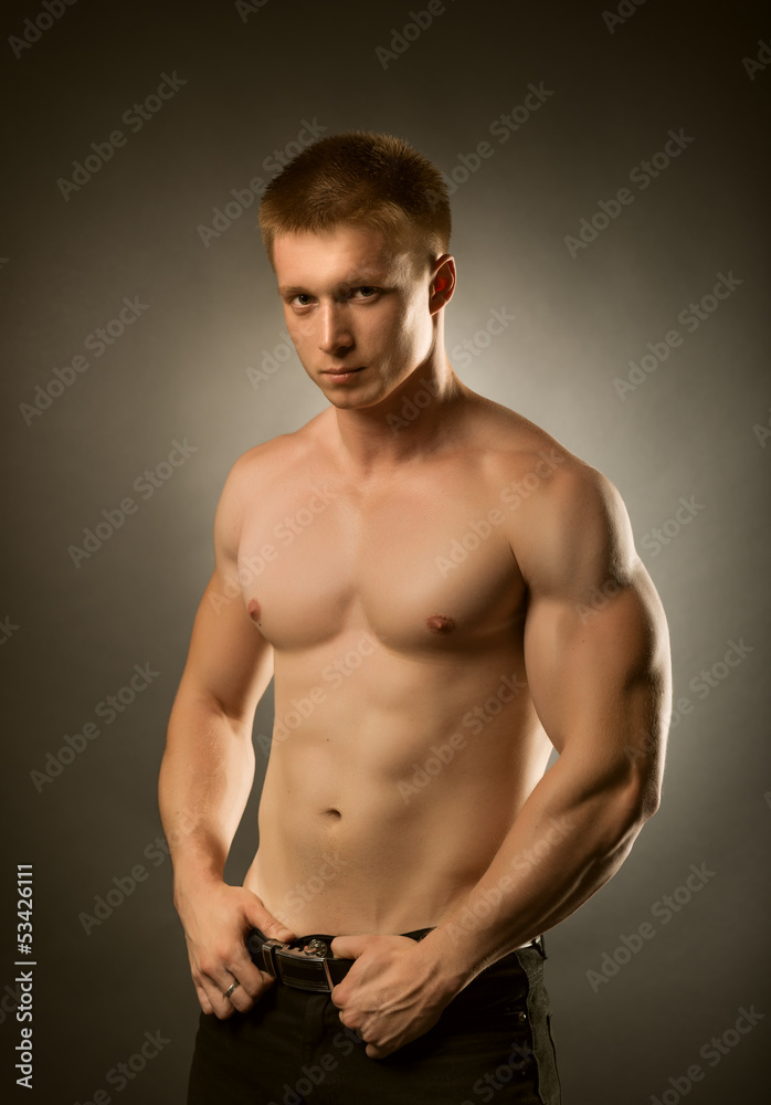 Healthy muscular young man  posing in studio
