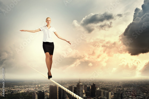 Businesswoman balancing on rope