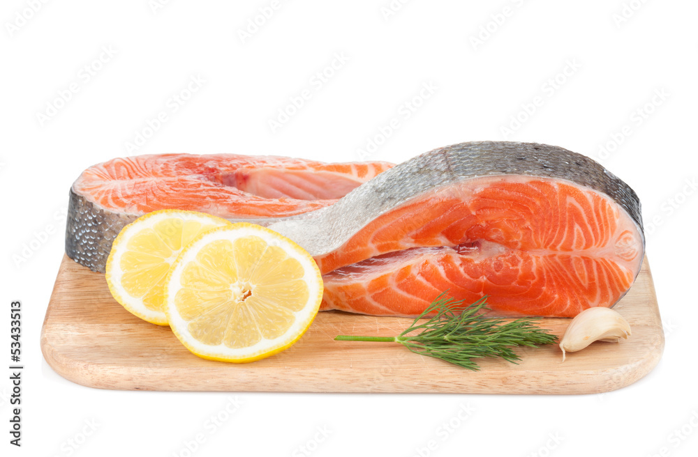 Salmon steaks on cutting board with lemons and herbs Salmon steaks on cutting board with lemons and herbs