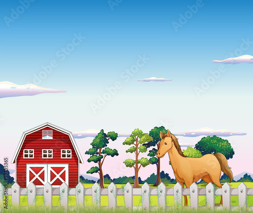 A horse inside the fence with a barn