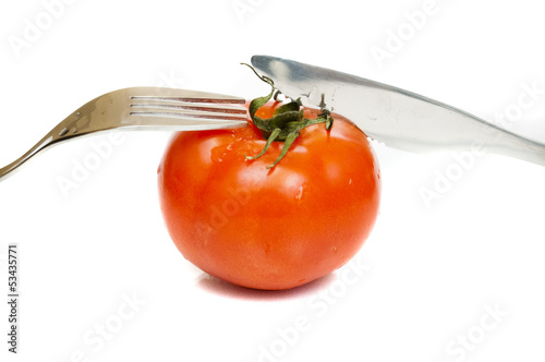 red ripe tomato with a fork and knife