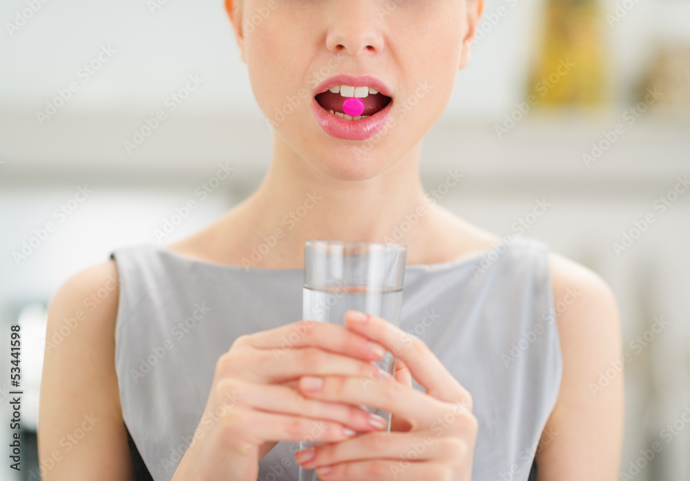 Closeup on young woman with pill in mouth - obrazy, fototapety, plakaty 
