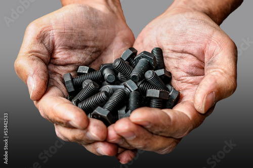 Workers hands with a few black bolts